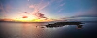 an aerial view of an island at sunset